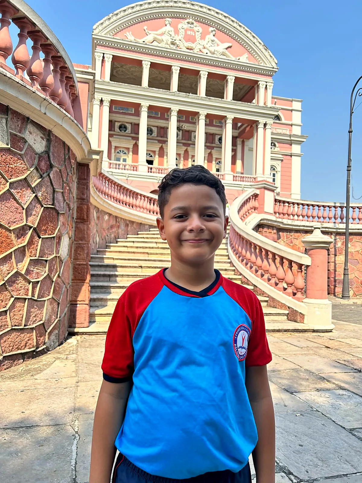 Aluno de uniforme em frente ao Teatro Amazonas, durante passeio da escola
